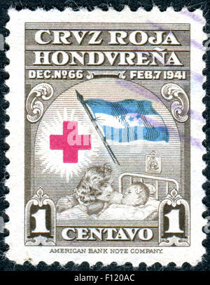 HONDURAS - CIRCA 1945: Postage stamp printed in Honduras, shows Red Cross, Flag, Mother and Child, circa 1945 Stock Photo