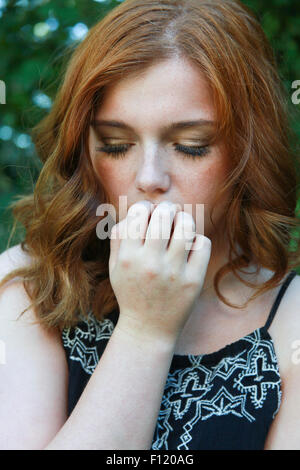 Beautiful young woman with red hair looking worried. Stock Photo