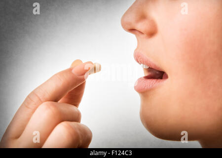 Closeup of woman taking pill Stock Photo