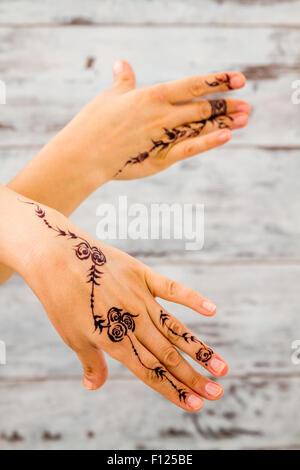 Woman hands without nail polish painted with floral figures using black henna Stock Photo
