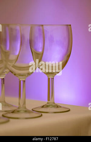 Empty Wineglasses on Table with Purple Light Behind Stock Photo