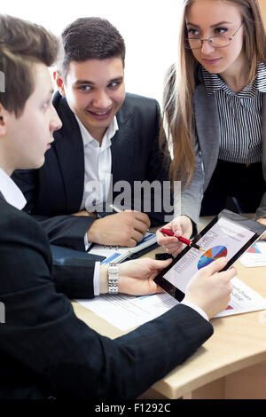 Smiling female manager explains corporate data to her associate Stock Photo