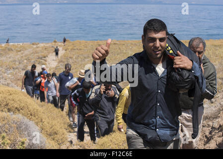 Lesbos, Greece. 25th Aug, 2015. Refugees head to the road leading to the car park from where buses will transport them to the identification center situated at the island's capital city, Mytilene. More than 30,000 refugees have reached the Greek island of Lesvos during August 2015, according to Amnesty International. © Nikolas Georgiou/ZUMA Wire/Alamy Live News Stock Photo