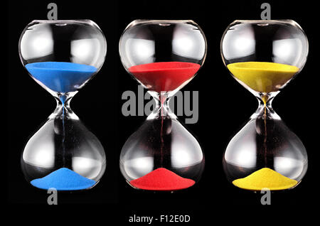 Three hourglasses with colorful sand, blue, red and yellow,running through the glass bulbs measuring the passing time
