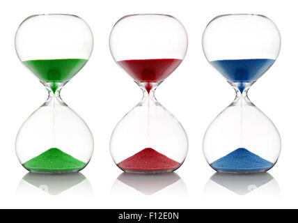 Colored sand, red, green and blue, running through glass hourglasses