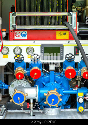Rolled hose and pump on fire fighting vehicle Stock Photo