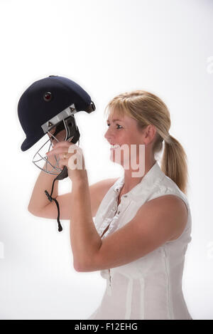 Portrait of a woman cricketer adjusting her safety helmet Stock Photo