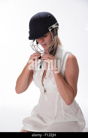 Portrait of a woman cricketer adjusting her safety helmet Stock Photo