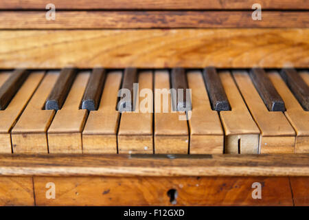 Close up front view of old wooden piano wtih brown and black keys. Stock Photo