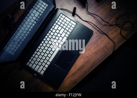 Modern Laptop on the Wooden Desk. Working at Night Theme. Stock Photo