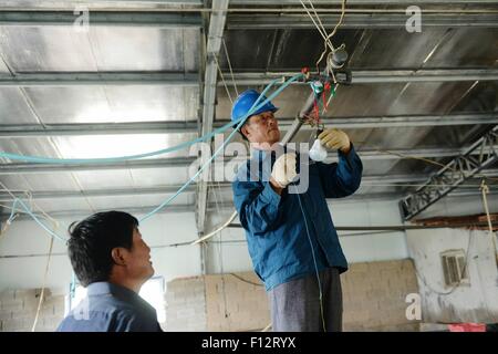 July 20, 2015 - Tsingtao, Shandong, CHN - Tsingtao, CHINA - July 20 2015: (EDITORIAL USE ONLY. CHINA OUT) Wu Deqing, the only electrician on Muguan Island. It is located in Boli Town of Tsingtao. The name is given by the story that First Emperor of Qin went to Langya Pavilion to ask for immortality, and his officers took a bath on the island. There are 56 families and 50 families live on aquiculture. Wu retired from army and went back to his hometown Muguan Island in 1976, and there is no electricity at all. Fishermen bought an electric generator and asked him to be in charge of generating ele Stock Photo
