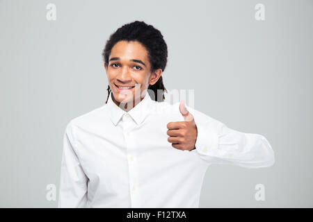 Happy afro american businessman showing thumb up over gray background Stock Photo