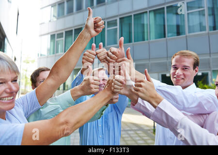 Successful group of business people holding their thumbs up Stock Photo