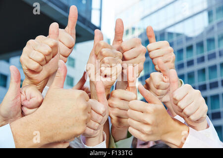 Successful business people holding many thumbs up Stock Photo