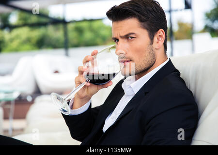 Confident young man drinking wine in restaurant Stock Photo