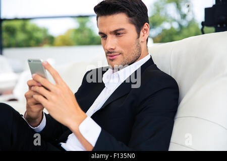 Confident businessman using smartphone in restaurant Stock Photo