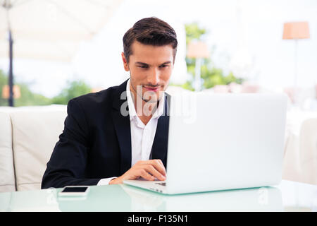 Handsome businessman using laptop in restaurant Stock Photo