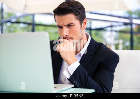 Confident businessman using laptop in restaurant Stock Photo