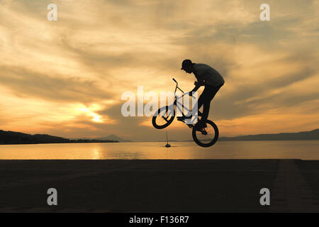 Stunning tricks of bmx biker against the sunset. Stock Photo