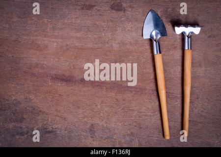 Small Gardening Tools on wooden table with copy space Stock Photo