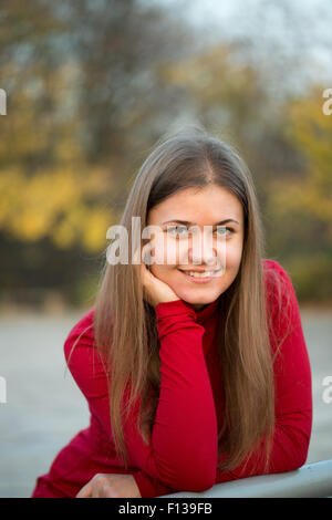 Portrait of beautiful girl wearing red pullover smiling on the autumn park Stock Photo