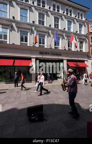 A saxophonist busking outside Brown Thomas department store on Grafton Street in Dublins city center. Dublin Ireland. Stock Photo