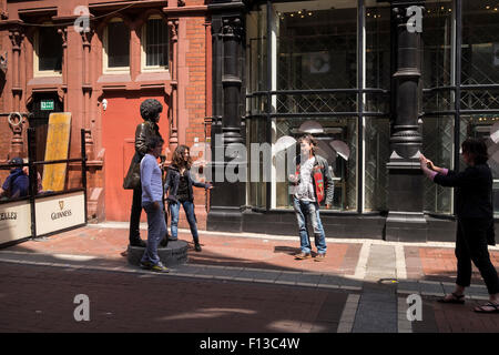 Tourists posing for photos with the life size bronze statue of Phil Lynnot on Harry Street in Dublins city center Dublin Ireland Stock Photo
