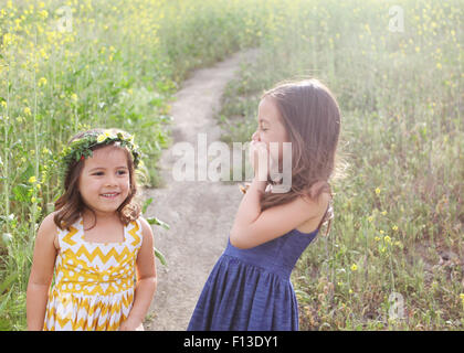 Two girls laughing in a  flower field