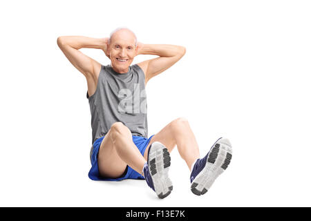 Active senior man in sportswear doing stomach crunches and looking at the camera isolated on white background Stock Photo