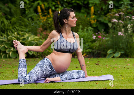 Portrait of a pregnant woman doing yoga in the garden Stock Photo
