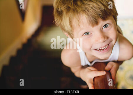 Portrait of a boy sliding down the banisters of a staircase Stock Photo