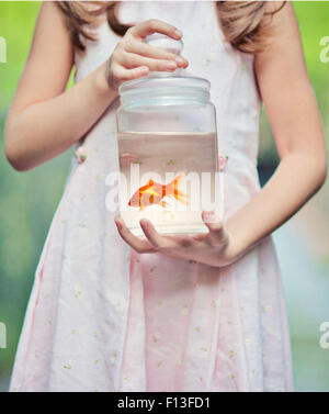 Girl holding a Goldfish in a jar