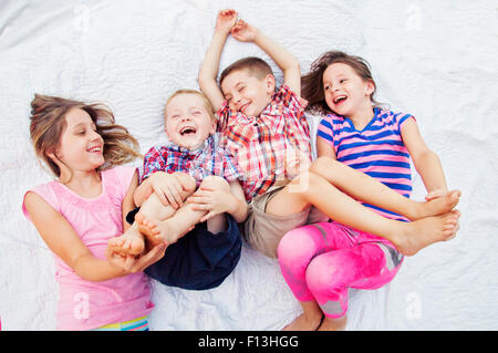 Two sisters tickle two brothers feet Stock Photo