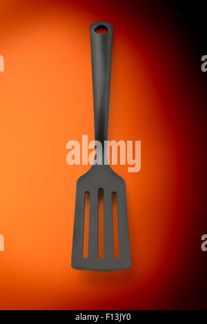 Black plastic kitchen spatula vertical in closeup Stock Photo