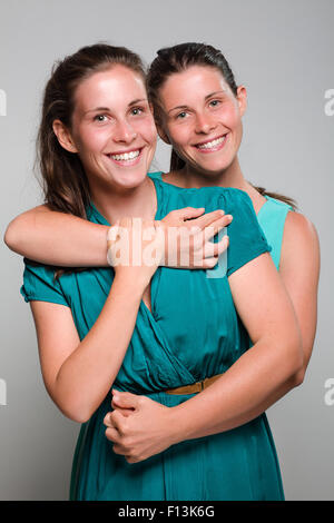Two Smiling Twin Sisters Hugging Stock Photo