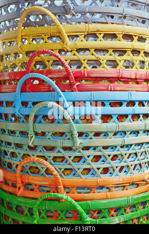 Craft background. Pile of the new traditional bali bamboo baskets painted in bright colors. Stock Photo