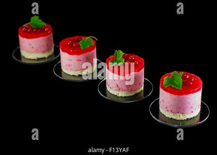 Four small redcurrant cakes decorated with berries Stock Photo