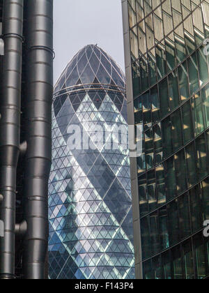 Stormy and sunny slkies light up the Gherkin and the lloyds Building in the City of London and St.andrew Undershaft Church Stock Photo