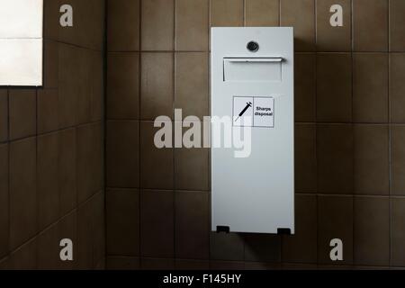 Needle disposal bin for drug users, in public toilet Stock Photo