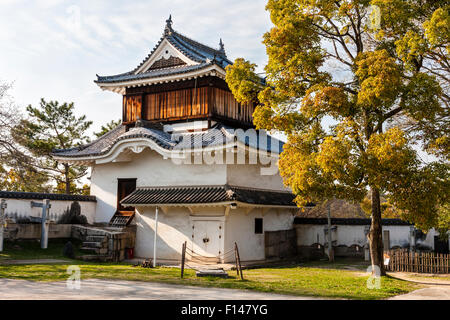 Japan, Okayama castle. The original two level Tsukimi yagura, a corner turret. Top story with vertical brown wooden boarding. Daytime, blue sky. Stock Photo