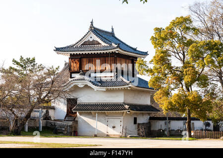 Japan, Okayama castle. The original two level Tsukimi yagura, a corner turret. Top story with vertical brown wooden boarding. Daytime, blue sky. Stock Photo