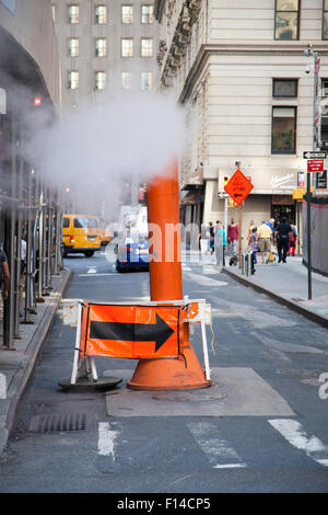 Steam vapor being vented through a typical Con Edison orange stack Stock Photo