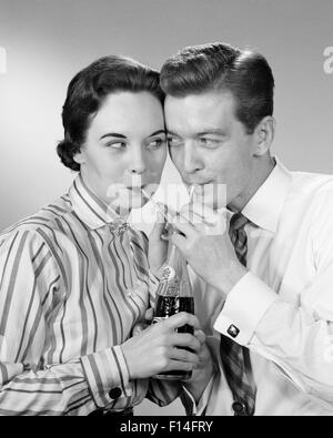 1950s ROMANTIC COUPLE HEAD TO HEAD SHARING A SODA POP COLA ONE BOTTLE TWO STRAWS