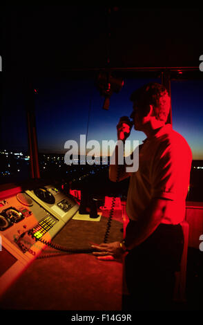 AIR TRAFFIC CONTROLLER IN CONTROL TOWER ON HAND HELD RADIO Stock Photo