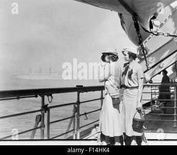 1930s TWO WOMEN FILMING WITH 8MM HOME MOVIE CAMERA ON DECK OF TRANSATLANTIC OCEAN LINER SHIP Stock Photo