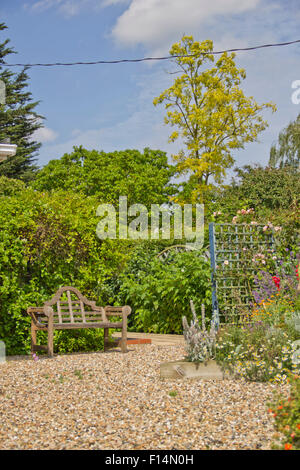 Wooden handmade brown bench in an english country garden Stock Photo