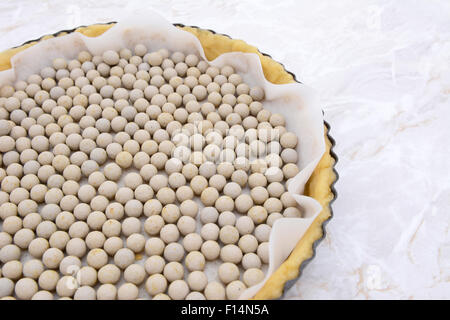 Close-up of pastry weights, ceramic beans, in an unbaked pie case lined with baking parchment Stock Photo