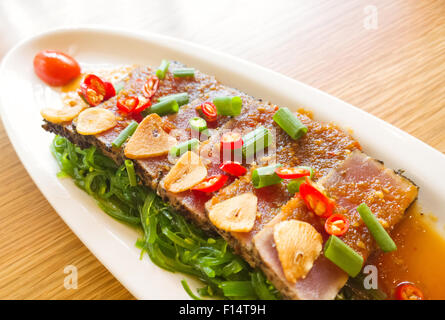smoke tuna spicy with salad frieze on wooden table Stock Photo