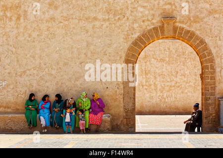 Moroccan people sit near the entrance of medina of Essaouira city in Atlantic coast, Morrocco Stock Photo