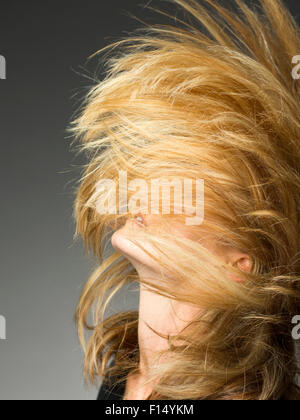 Blonde woman flipping hair in studio Stock Photo